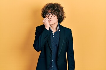 Obraz premium Handsome young man wearing business jacket and glasses looking stressed and nervous with hands on mouth biting nails. anxiety problem.