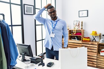 Young african man working as manager at retail boutique confuse and wondering about question....