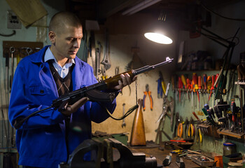 Gunsmith checks Kalashnikov assault rifle in a weapons workshop