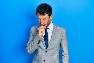 Handsome man with beard wearing business suit and tie feeling unwell and coughing as symptom for cold or bronchitis. health care concept.