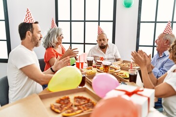 Group of middle age friends smiling happy celebrate birthday at home.