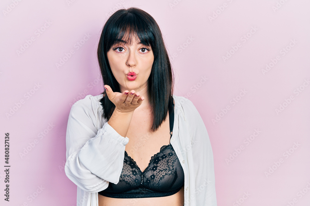 Poster Young hispanic woman wearing lingerie looking at the camera blowing a kiss with hand on air being lovely and sexy. love expression.