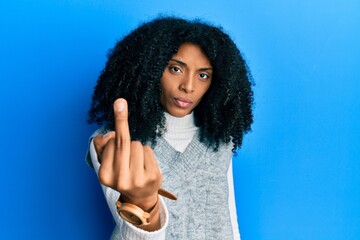 African american woman with afro hair wearing casual winter sweater showing middle finger, impolite and rude fuck off expression