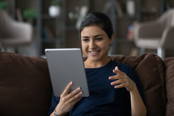 Happy attractive young Indian woman holding web camera call conversation using digital computer...
