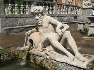 Hellbrunn Palace Trick Water Fountains Park, Austria,  Looking at a Statue of Poseidon Pouring Water into the Pond