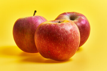  Group of red apples fruits over yellow background