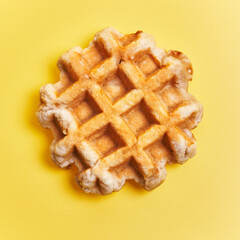  Single delicious waffle over yellow background