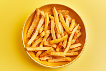  Bowl of french fried potatoes over yellow background