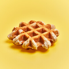  Single delicious waffle over yellow background