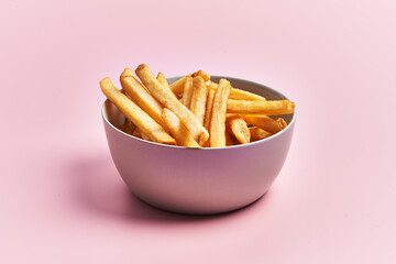  Bowl of french fried potatoes over pink background