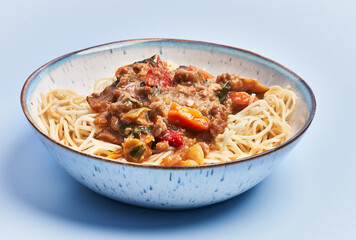  Plate of delicious spaghettis with meat and vegetables over blue background