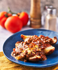  Plate of roasted potatoes with sauce on marble surface