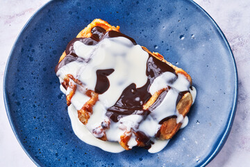  Plate of delicious waffle with chocolate and cream on marble surface