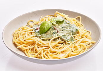  Plate of italian spaghetti pasta with pesto sauce over white isolated background