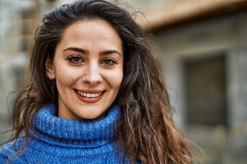 Young hispanic woman smiling happy standing at the city.