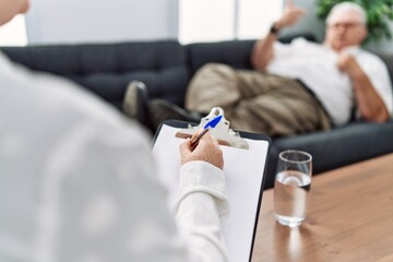 Middle age grey-haired man having psychology session at psychology clinic