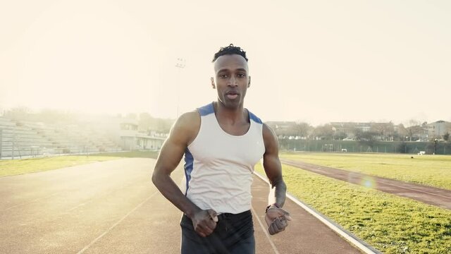 Male athlete run on running track in a stadium - Slow motion video of runner training outdoors - Sport concept