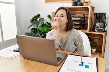 Brunette woman with down syndrome working at business office