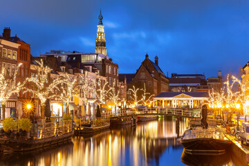 Fototapeta na wymiar Night Leiden canal Oude Rijn, City Hall and bridge Koornbrug in Christmas illumination, South Holland, Netherlands.