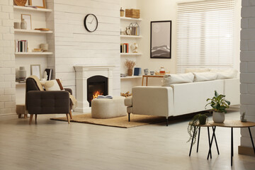 Stylish living room interior with comfortable sofa and decorative fireplace