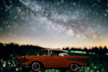 Retro car toy model in front of the night sky