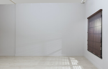 Empty room with white walls, large window and wooden floor