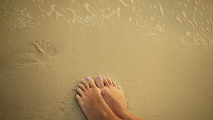 View top, from above. The woman feet relaxed are stand on the sa