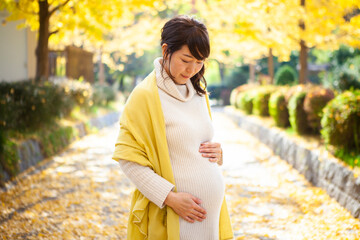 銀杏並木に佇む妊婦の女性