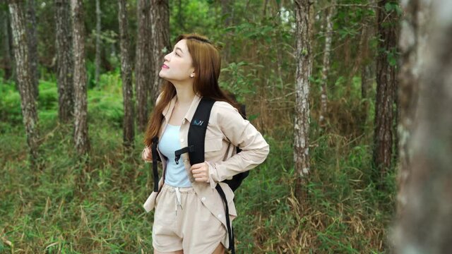 young woman carrying a backpack travel in the forest