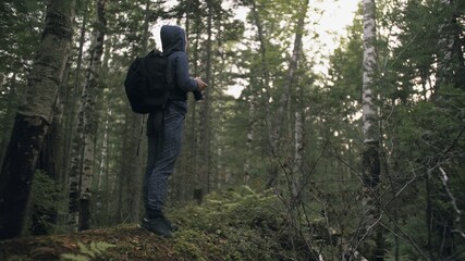 Fototapeta premium Traveler photographing scenic view in forest. One caucasian woman shooting nice magic look. Girl take photo video on dslr mirrorless camera.