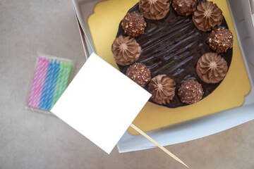 Chocolate birthday cake with blank label and candles
