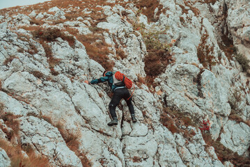 A male climber overcoming a difficult climbing route on the rock mountain adventure travel extreme...
