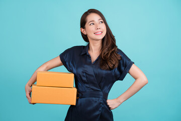 Portrait beautiful young asian business woman with brown box ready for shipping on blue background,...
