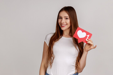Like button of social media. Smiling woman holding heart icon, recommending to follow and share...