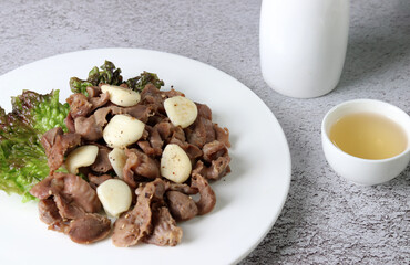 Fried chicken gizzard and garlic. Stir-fried chicken gizzard and garlic served with alcohol.

