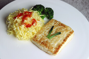 Tofu steak and vegetables. Vegetarian menu with vegetables and beans.
