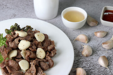 Fried chicken gizzard and garlic. Stir-fried chicken gizzard and garlic served with alcohol.
