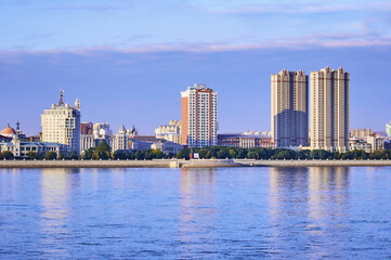 Fototapeta premium Russian-Chinese border along the Amur River. View from the embankment of the city of Blagoveshchensk, Russia to the city of Heihe, China. A mixture of architectural styles.