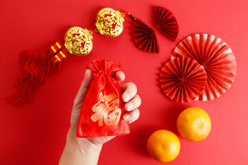Chinese new year festival decoration with red envelopes and red Chinese folded fans on red background.