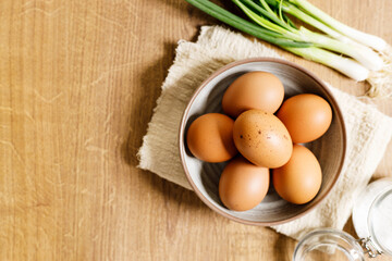 brown eggs in a bowl on wooden table..