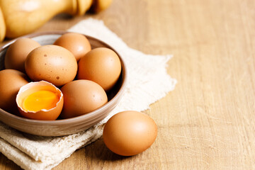 brown eggs in a bowl on wooden table..