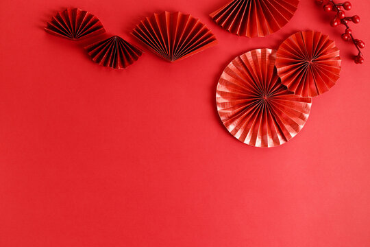 Chinese new year festival decoration with red envelopes and red Chinese folded fans on red background.