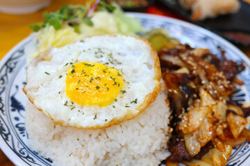 There is a fried egg on top of a Vietnamese fried rice dish.