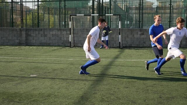 Junior football teams having scrimmage and struggling for ball