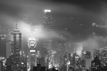 Misty night view of Victoria harbor in Hong Kong city