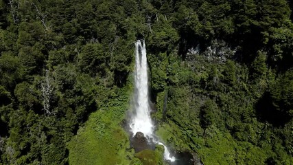 Dolly in of the waterfall el salto el leon surrounded by vegetation and with a constant rainbow - crane shot