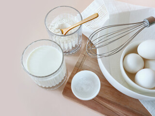 Ingredients for pancakes on a light background. Flour, milk, eggs, whisk. Pancakes recipe. Shrovetide. Ingredients. Cook at home. home preparation