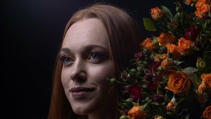 portrait of a beautiful girl with long hair, with roses on a black background