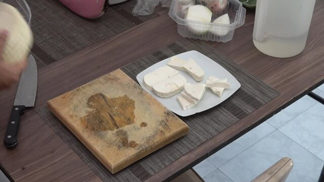 Cutting Mexican cheese on a wooden board