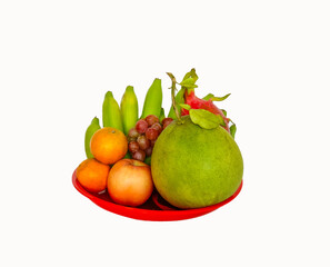 mixed fruit on red plastic bowl  such as : pomelo,dragon fruit, orange,banana on a white background . natural food concept, fruit for chinese new year  ,